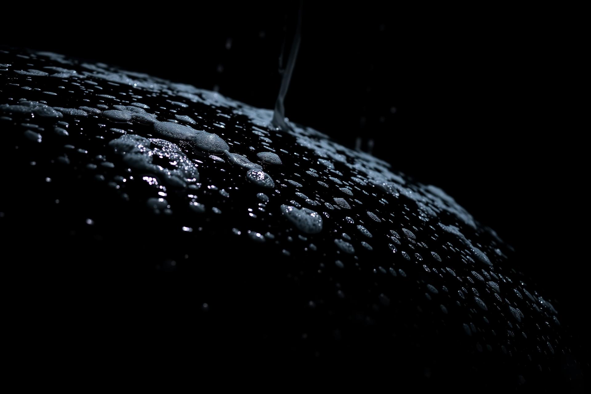 Water beading on a freshly detailed black car